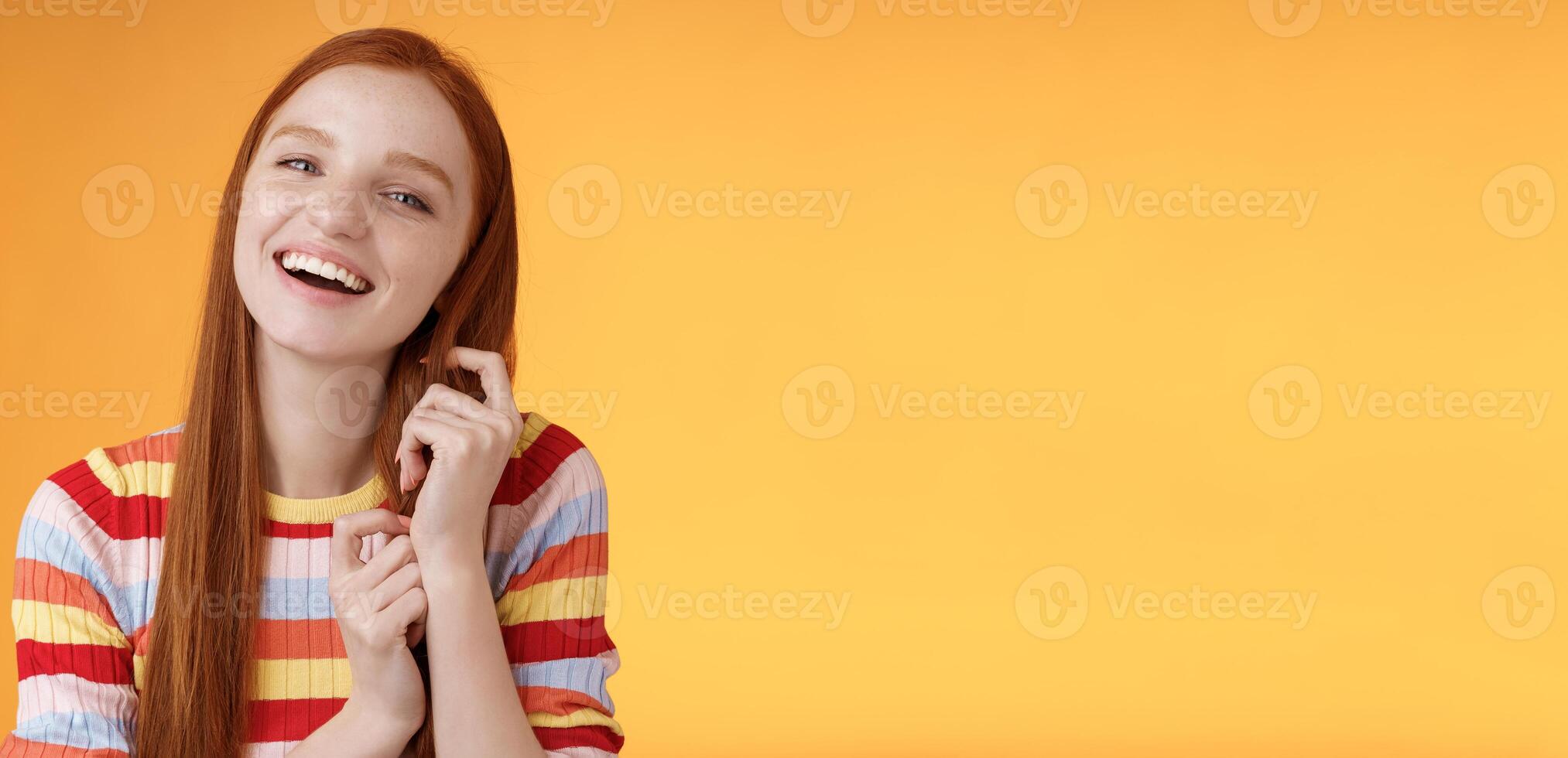 Silly good-looking flirty lively redhead young girl laughing playing coquettish ginger hair strand chuckling amused funny boyfriend jokes having fun awesome romantic date, orange background photo