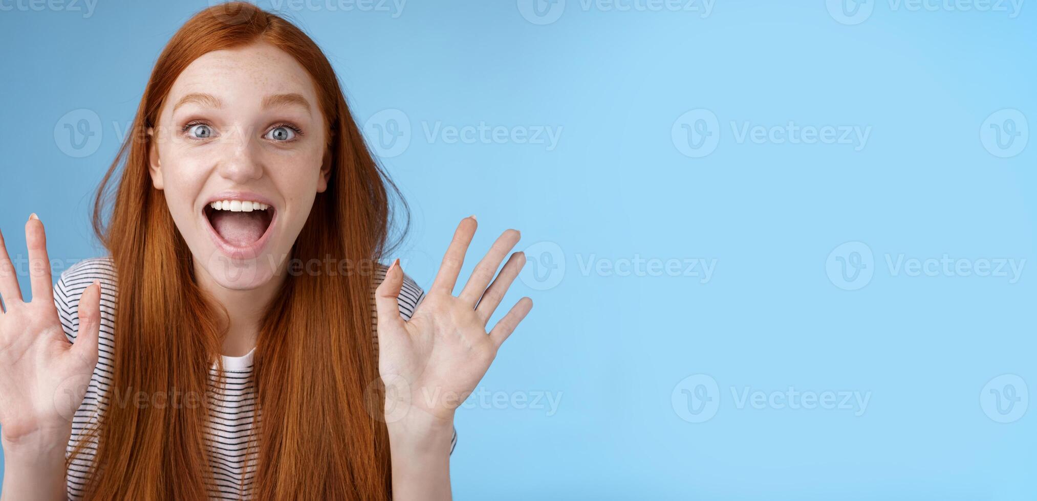 Excited charismatic happy lively redhead young funny woman smiling thrilled open mouth fascinated wide eyes surprised staring adore cool new product raise palms waving hello, show ten dozen photo