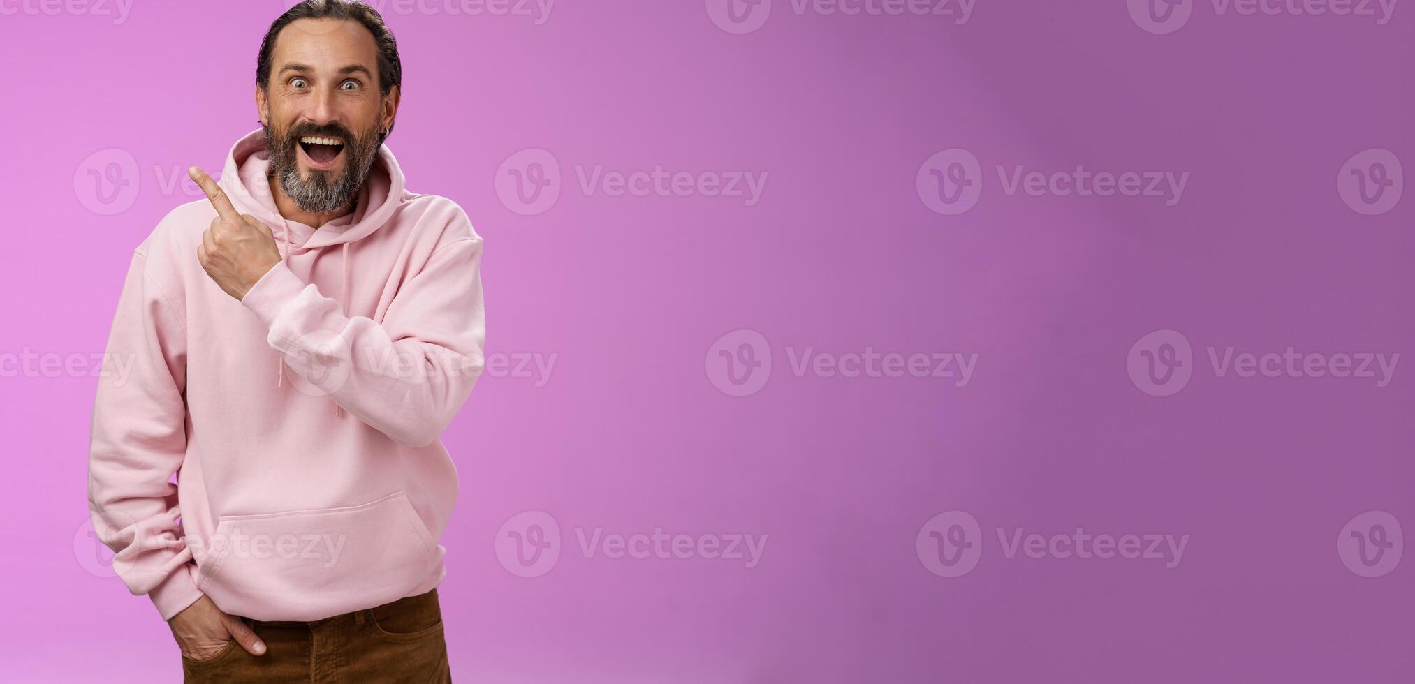 Speechless excited impressed handsome bearded man grey hair widen eyes surprised astonished wow drop jaw gasping thrilled pointing upper left corner see famous star, purple background photo