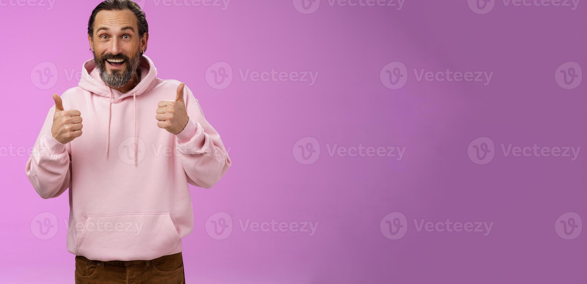 Energized supportive happy charming hipster mature guy bearded grey hair show thumbs up gesture yes approval sign totally agree cheering root for friend like awesome idea, standing purple background photo