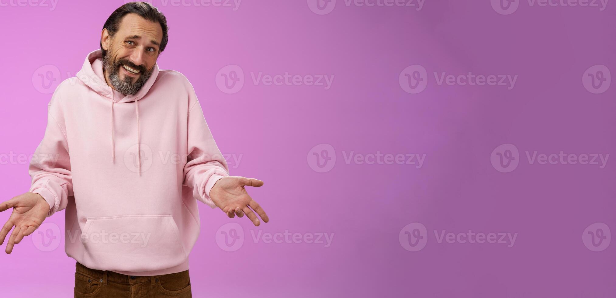 Portrait doubtful unsure awkward mature man shrugging spread hands sideways clueless cringing frowning hesitant cannot say yes no facing hard decision standing perplexed purple background photo