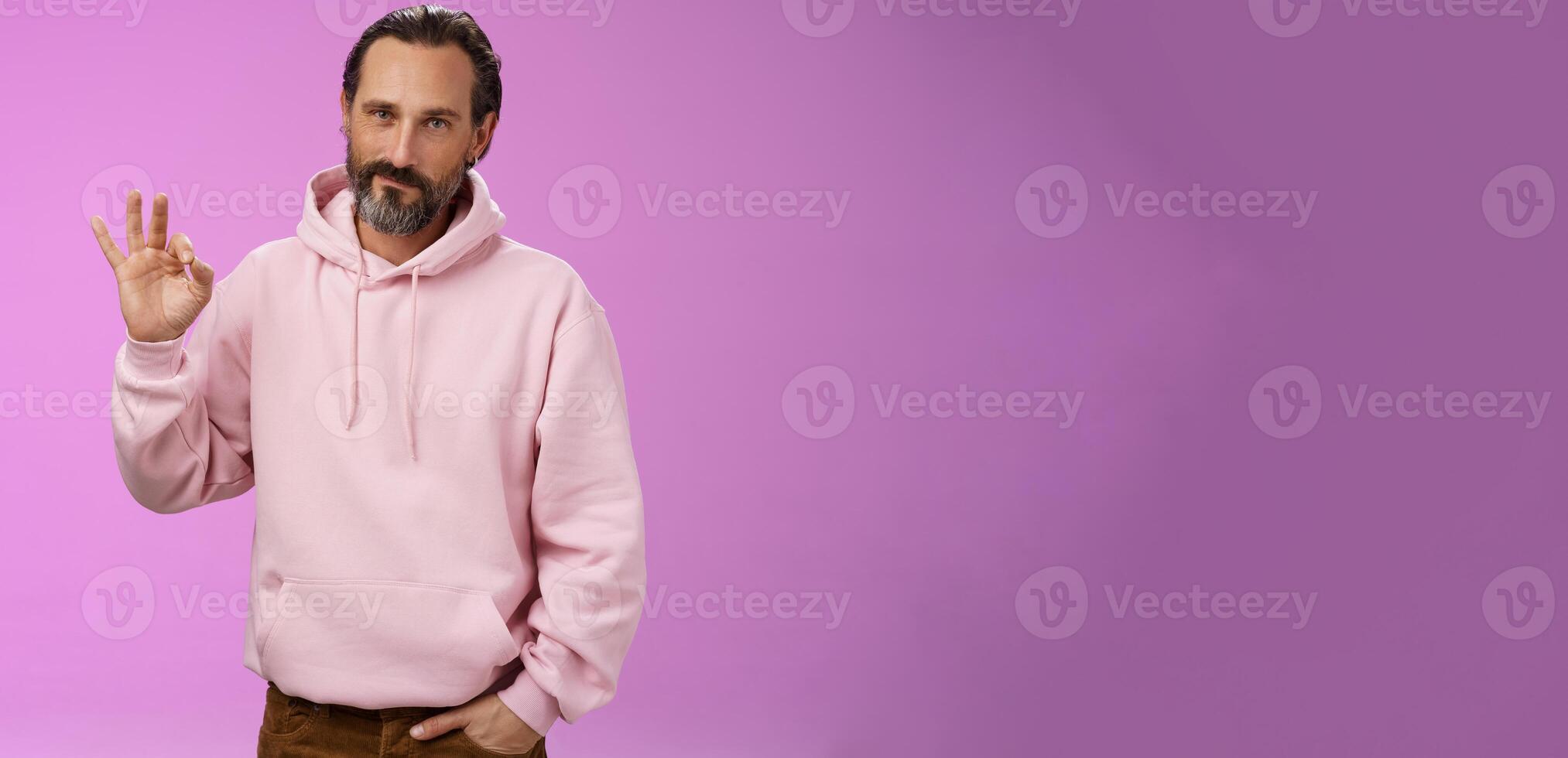 Confident good-looking lucky old macho guy bearded grey hair in stylish pink hoodie hold hand pocket show okay ok approval gesture smirking delighted agree daughter choice, posing supportive photo