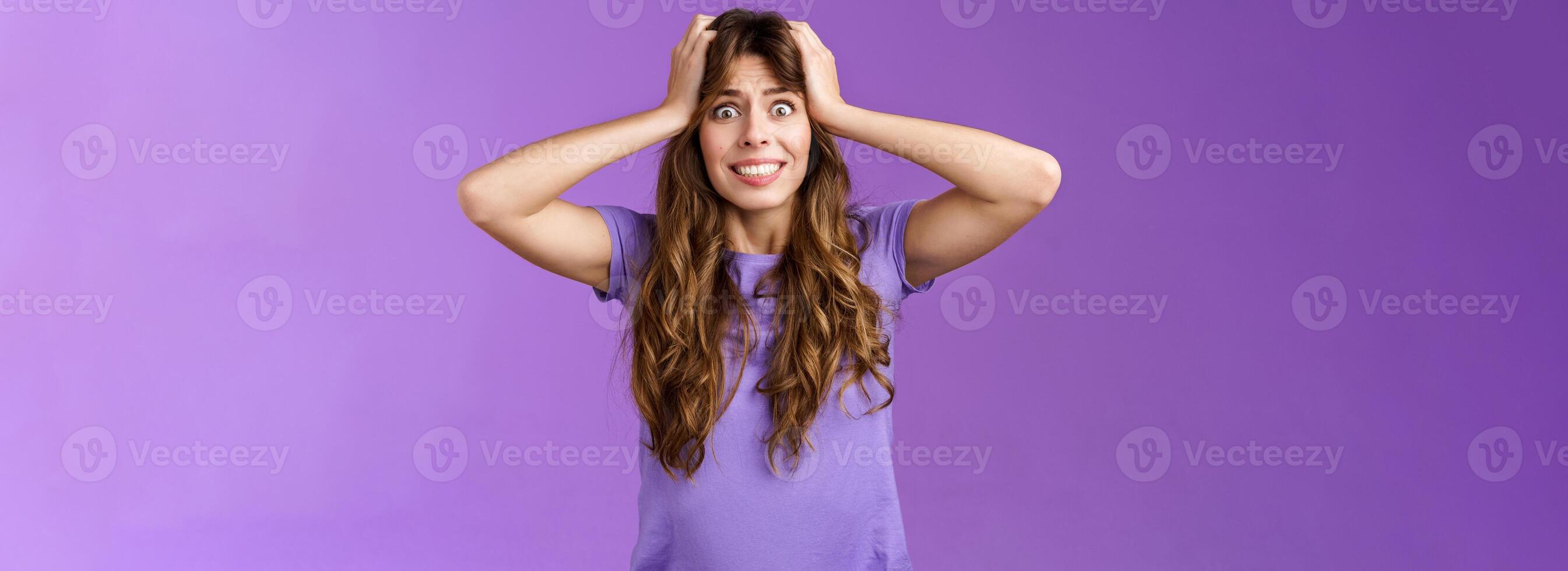 Girl feel panic troublesome perplexed situation clench teeth intense stare camera grab head distressed upset going insane crazy pissed popping eyes feel rage disappointment stand purple background photo