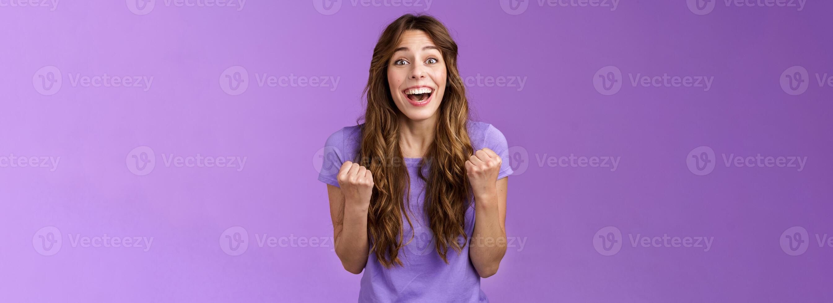 Cheerful cute devoted curly girl smiling broadly rooting for friend fist pump grinning admiration fan watching game favorite team wanna win see success celebrating triumphing joyfully photo