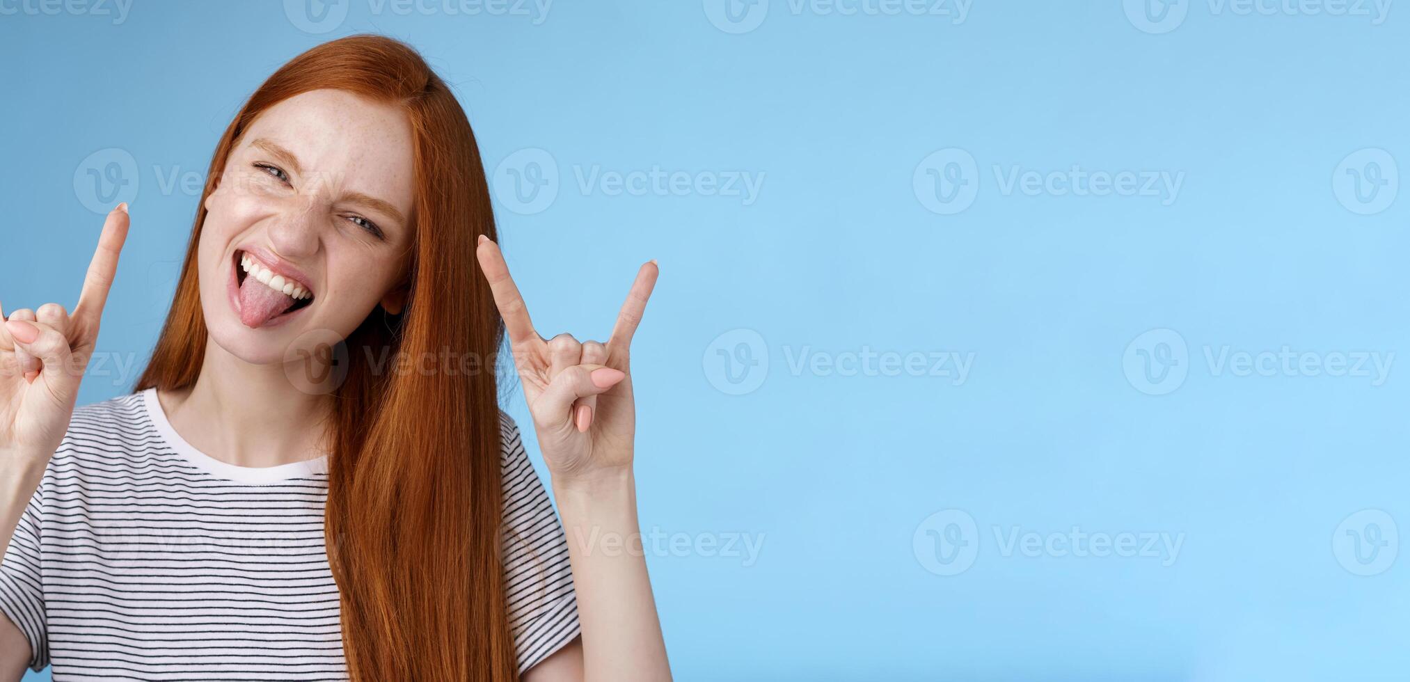 Daring carefree playful excited good-looking funny redhead girl having fun show tongue squinting do thrilled grimace make rock-n-roll heavy metal sign enjoy awesome party cool concert photo