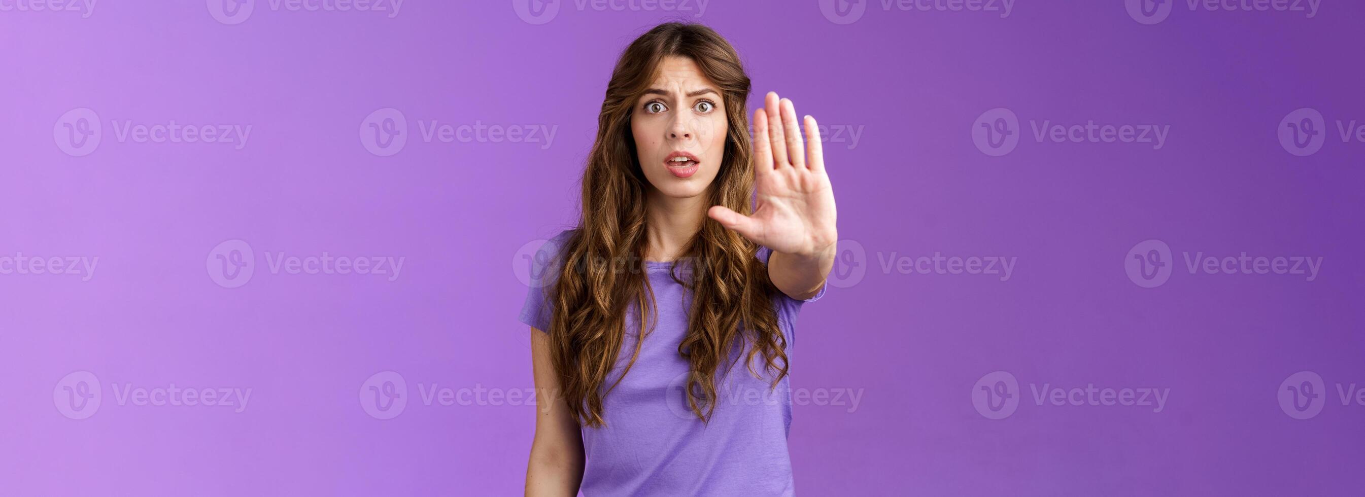 Worried shocked curly-haired woman gasping stare camera anxiously pull hand stop sign begging end prohibiting friend drive after drinking stand purple background forbid warn you purple background photo