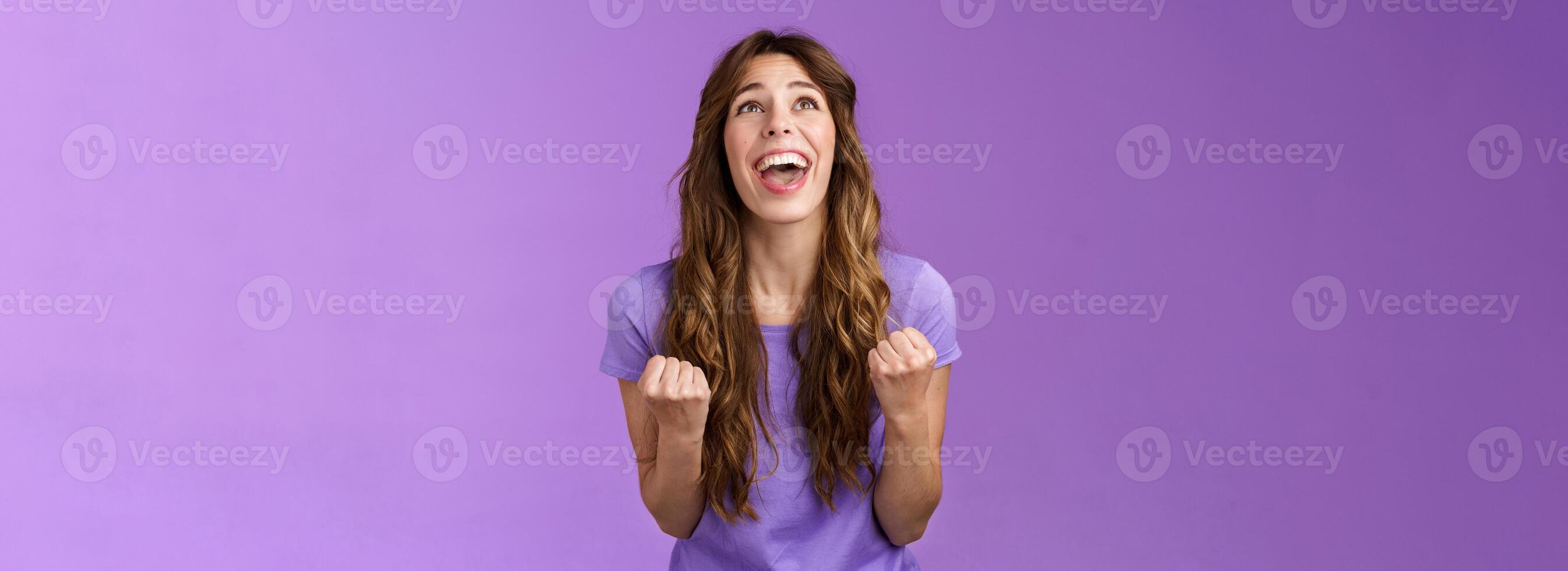 Relieved happy girl thank god awesome achievement celebrate success implore lord grateful fist pump yelling raise head up sky triumphing good news stand purple background joyful positive reaction photo