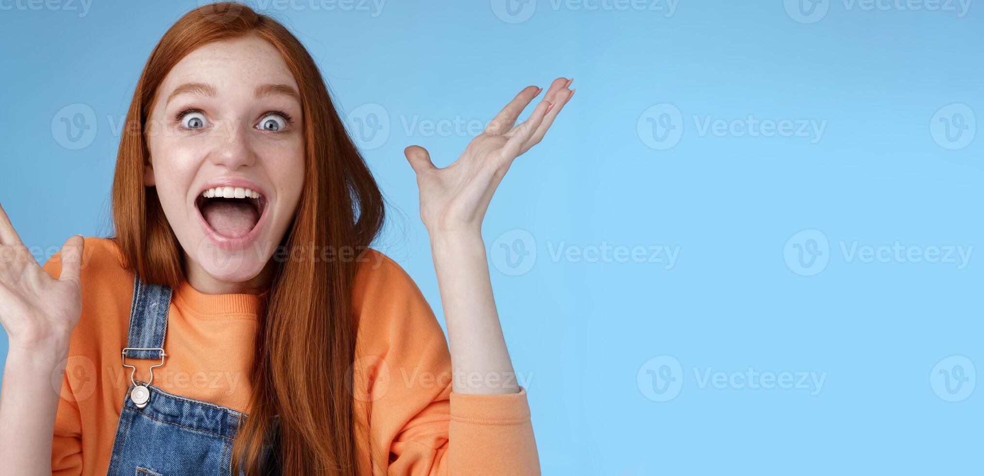 sorprendido asombrado sensible abrumado joven contento pelirrojo niña recibir increíble fantástico premio amplio ojos asombrado levantamiento manos triunfando ganar lotería celebrando alegremente foto