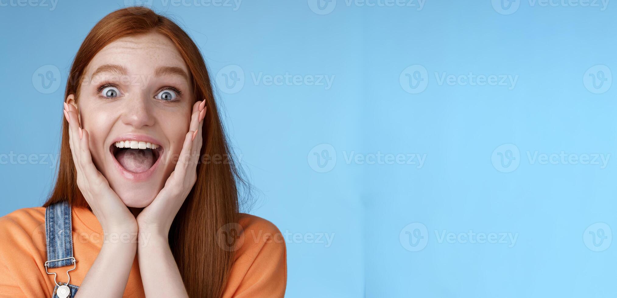 Impressed excited overwhelmed young redhead girlfriend fan screaming thrilled express afection adore awesome music band yelling happily reacting surprised astonished, standing blue background photo