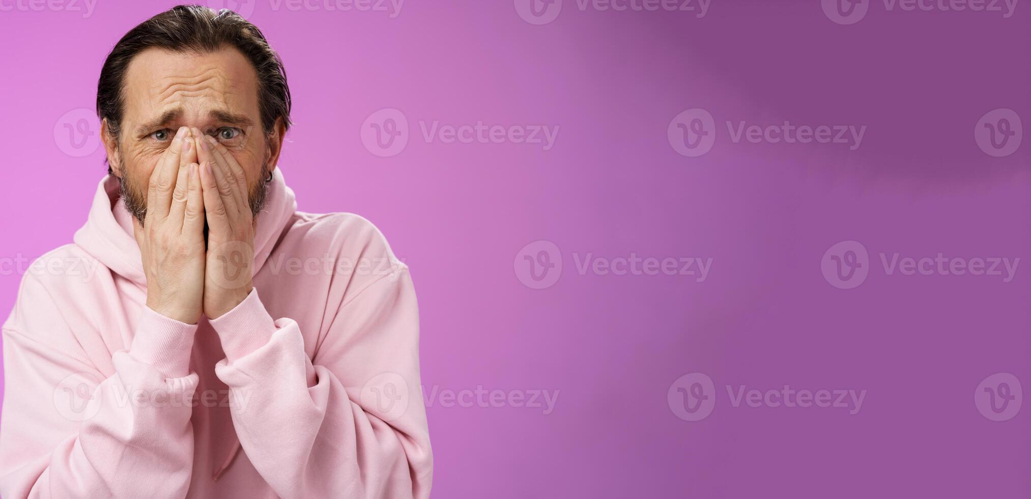 Shocked upset concerned adult husband grieving look heartbroken suffer sorrow distressed feelings frowning hold hands supplication beg god mercy, standing concerned troubled purple background photo