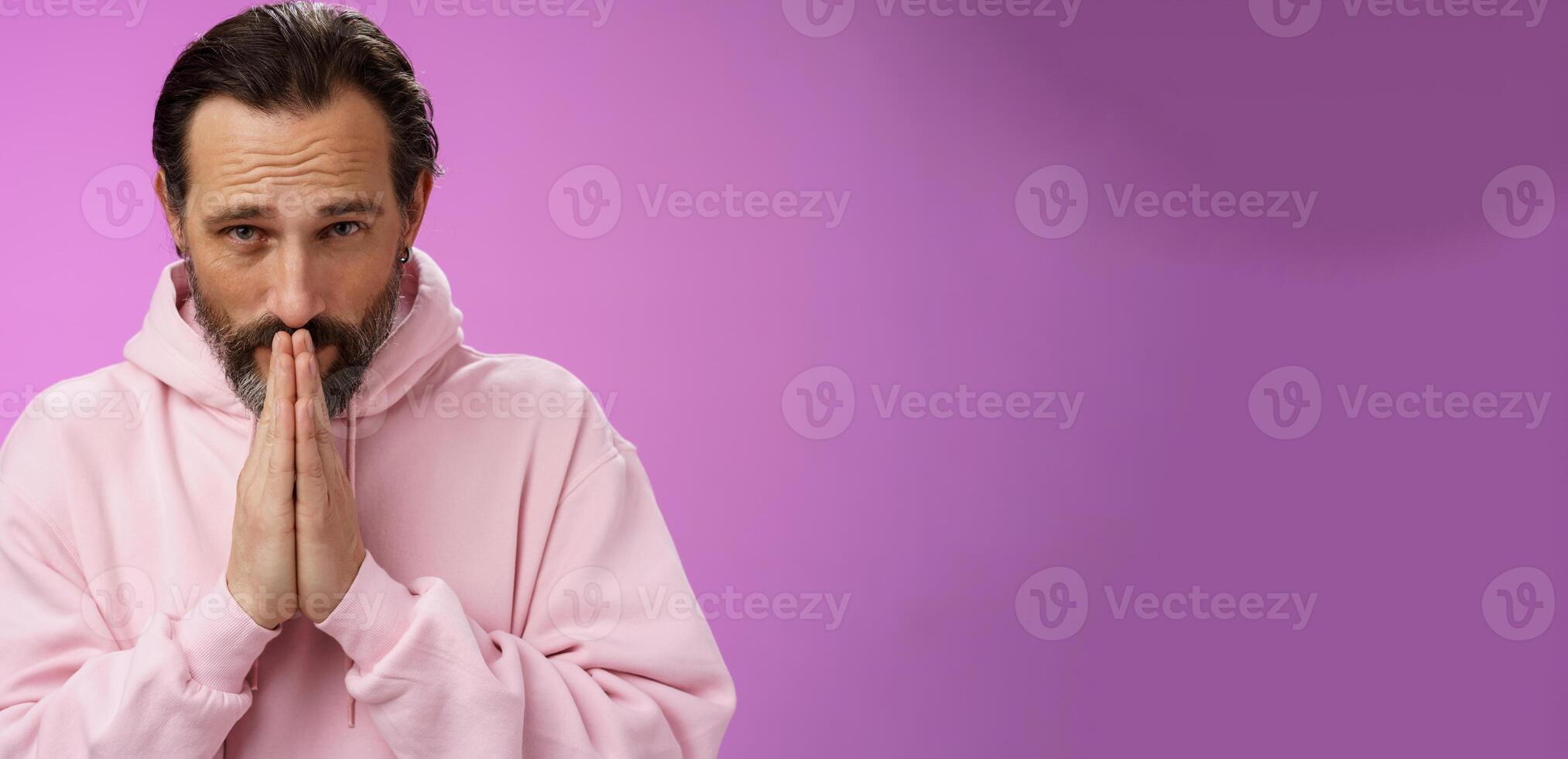 Worried intense serious-looking troubled handsome mature bearded man praying waiting important news nervously looking camera press palms supplicating wish wife alright, standing purple background photo