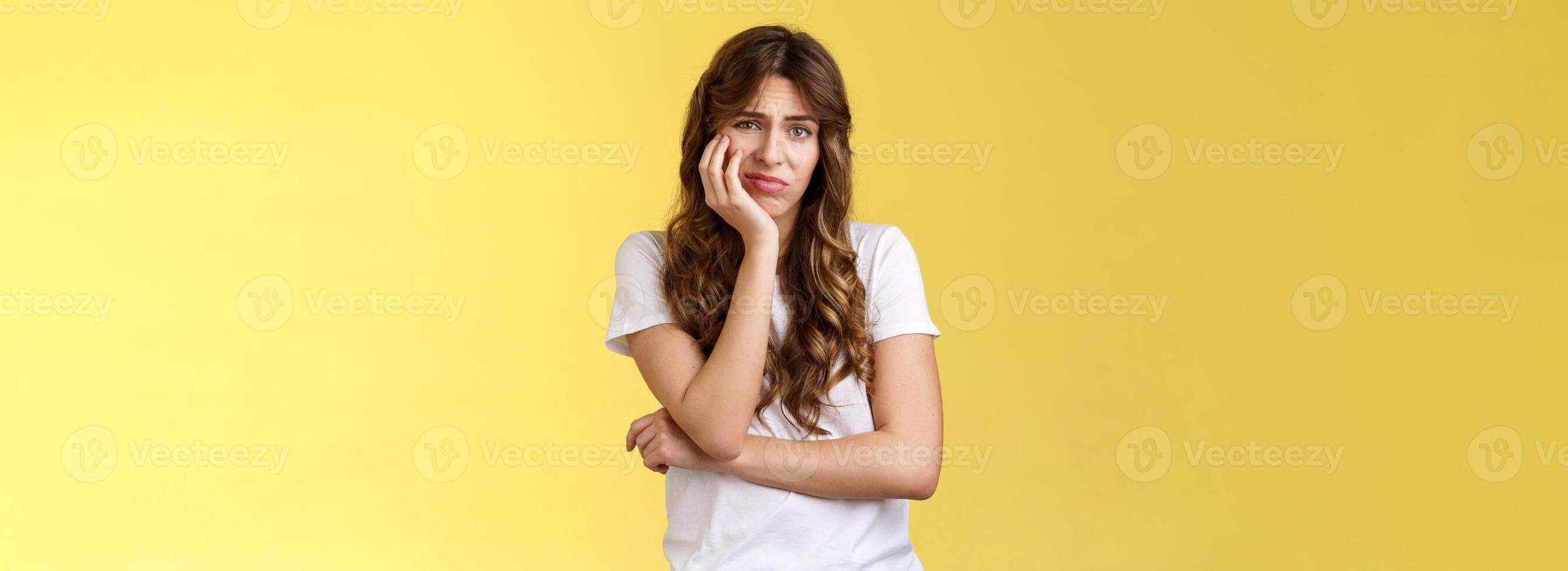 Upset distressed cute disappointed pretty girl feeling lonely regretting missed opportunity sighing sorrow sadness look camera apathetic indifferent lean face palm frowning jealous yellow background photo