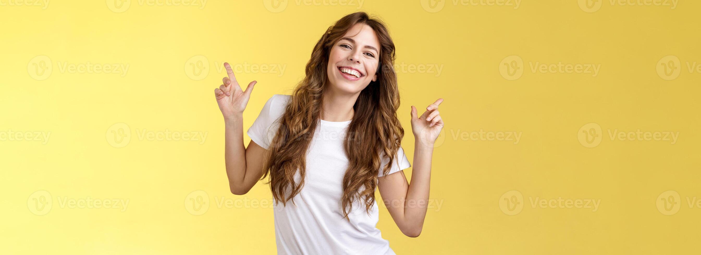 Outgoing cheerful attractive woman curly haircut wear casual white t-shirt dancing party having fun pointing up disco moves having fun smiling broadly enjoy holidays anticipating summer trip photo