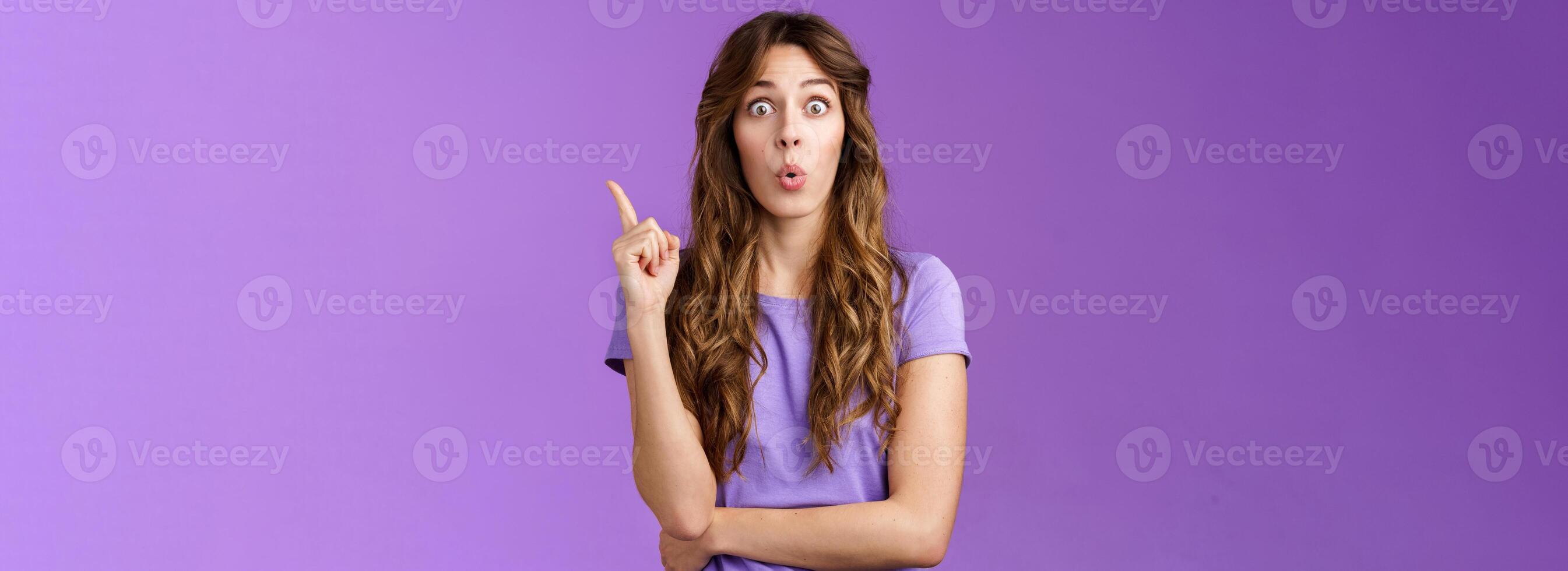 Got it eureka. Excited enthusiastic creative cute european girl raise index finger folding lips wow great found solution suggest perfect plan stand purple background thrilled give good advice photo