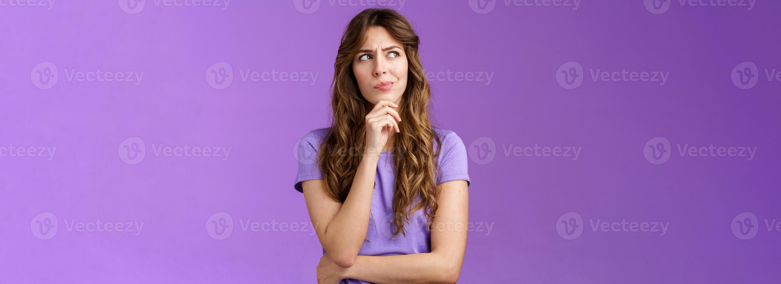 Girl trying solve problem thinking solution make hmm face smirk frowning thoughtful look away touch chin pondering making choice deciding how act what do stand purple background focused photo