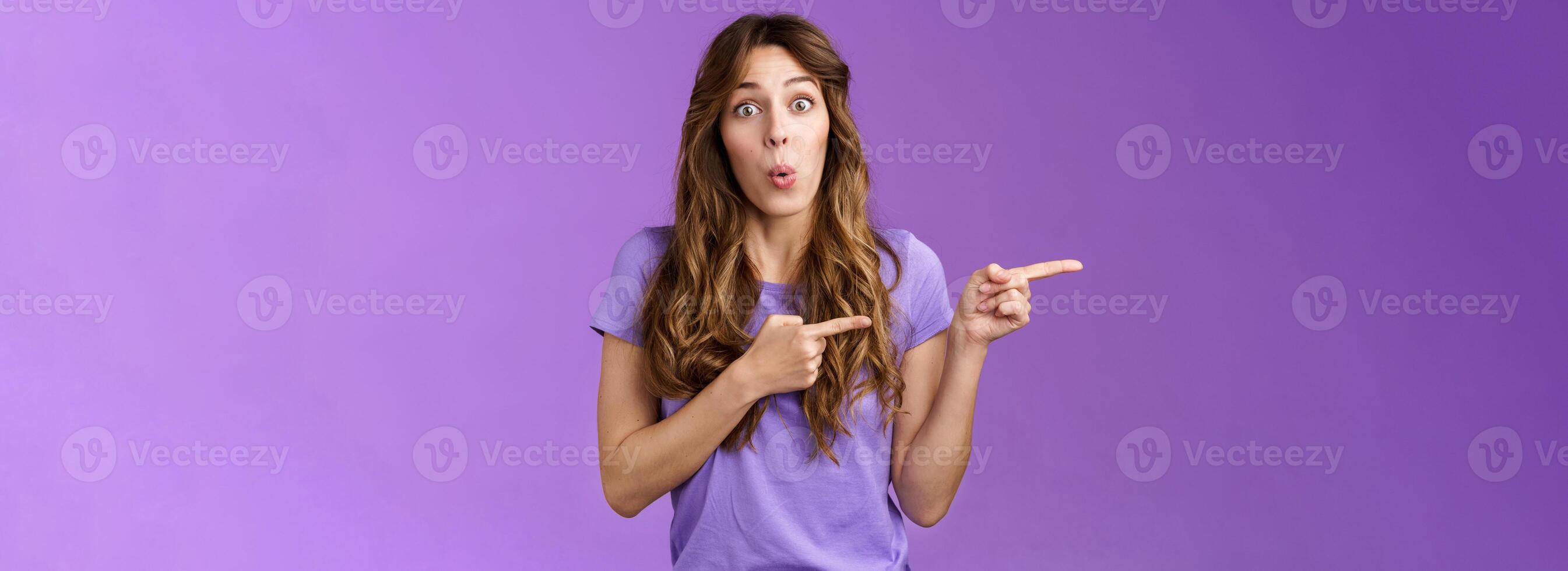 Amused surprised enthusiastic cute girlfriend wanna try advertising product folding lips excited look admiration excitement stand purple background curious interested what located direction photo