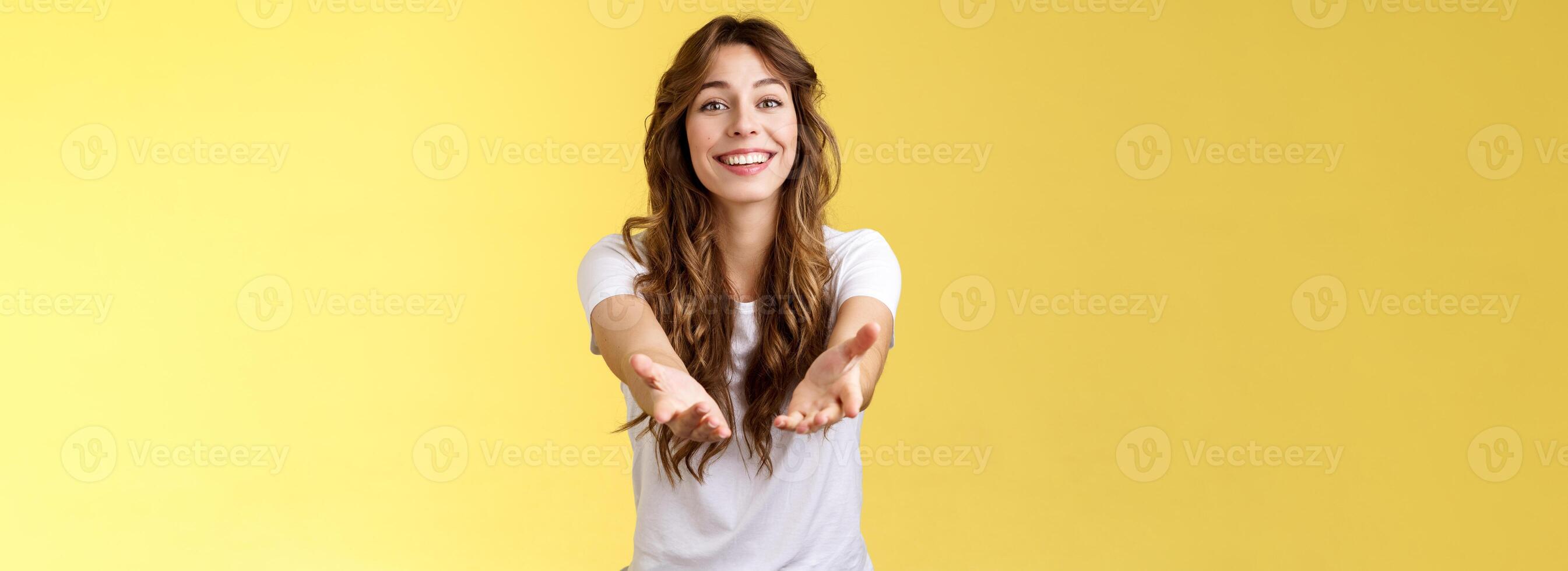 Let me hold it. Sincere tender touched charming curly-haired girl reaching you extend arms smiling lovely tempting grab precious thing receive gift stand yellow background grateful cheerful photo