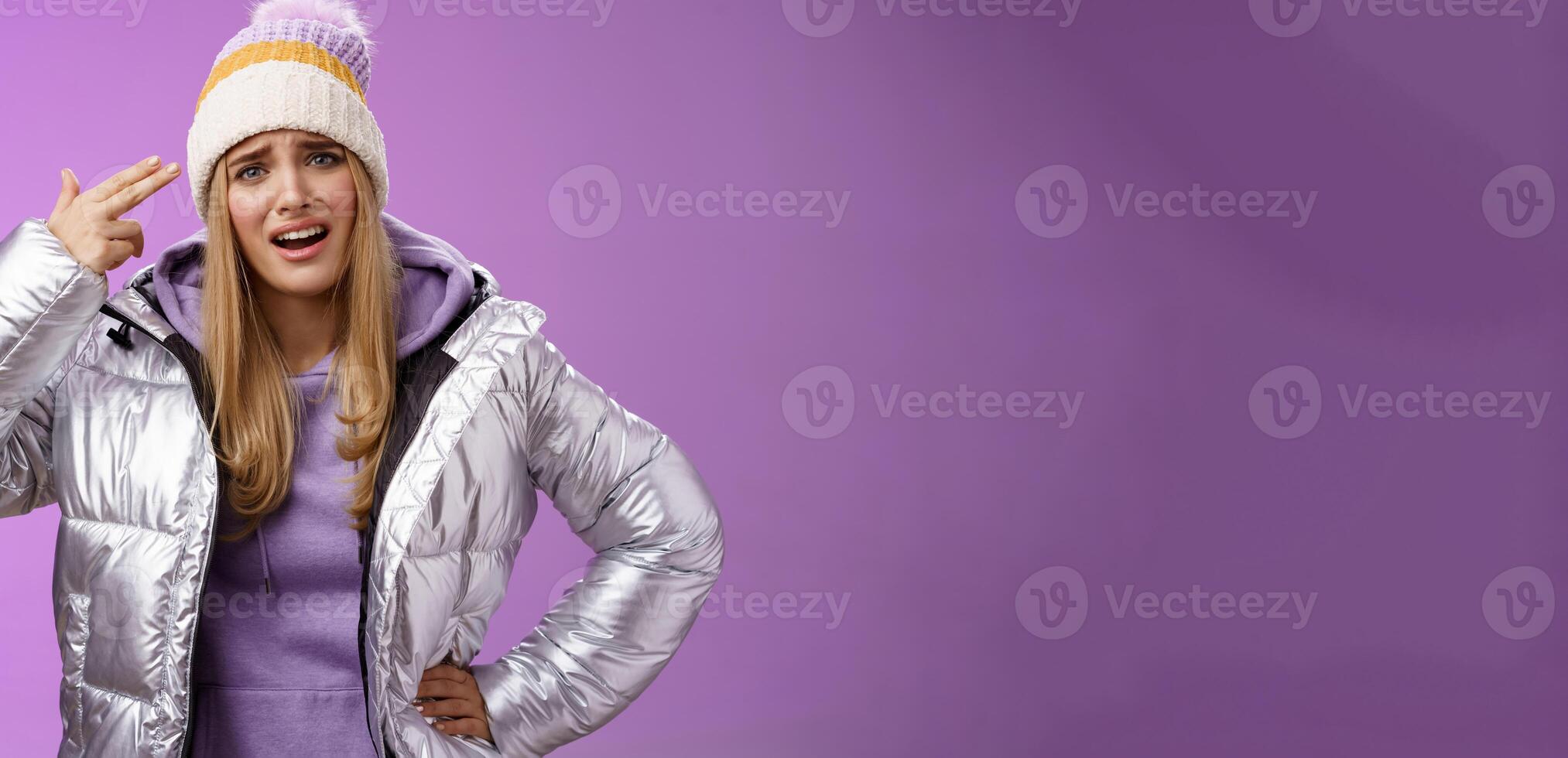 Disappointed pissed fed up young girlfriend complaining cannot stand anymore annoyed hold finger pistol near head blowing brains out head suicide gesture cringing disappointed, purple background photo