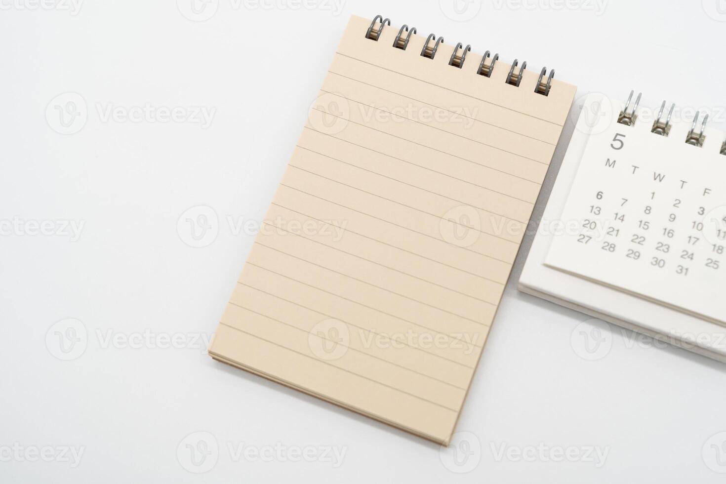 Empty Spiral notepad with brown lined papers and Simple desk calendar for MAY in isolated background. Memo concept with copy space. photo