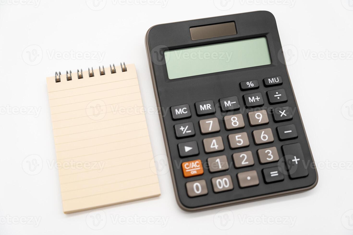 Spiral notepad and Calculator in isolated background. Blank one face brown paper note. empty sheet of brown lined papers. photo