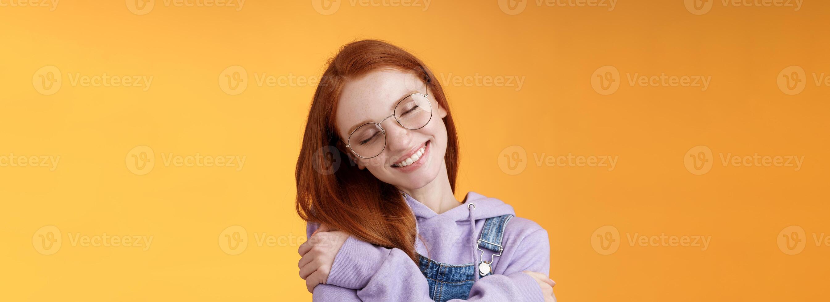 Close-up romantic lovely charming redhead girl enjoy warmth love tilting head close eyes dreamy imaging perfect date hugging herself embracing own body accept body-positivity orange background photo