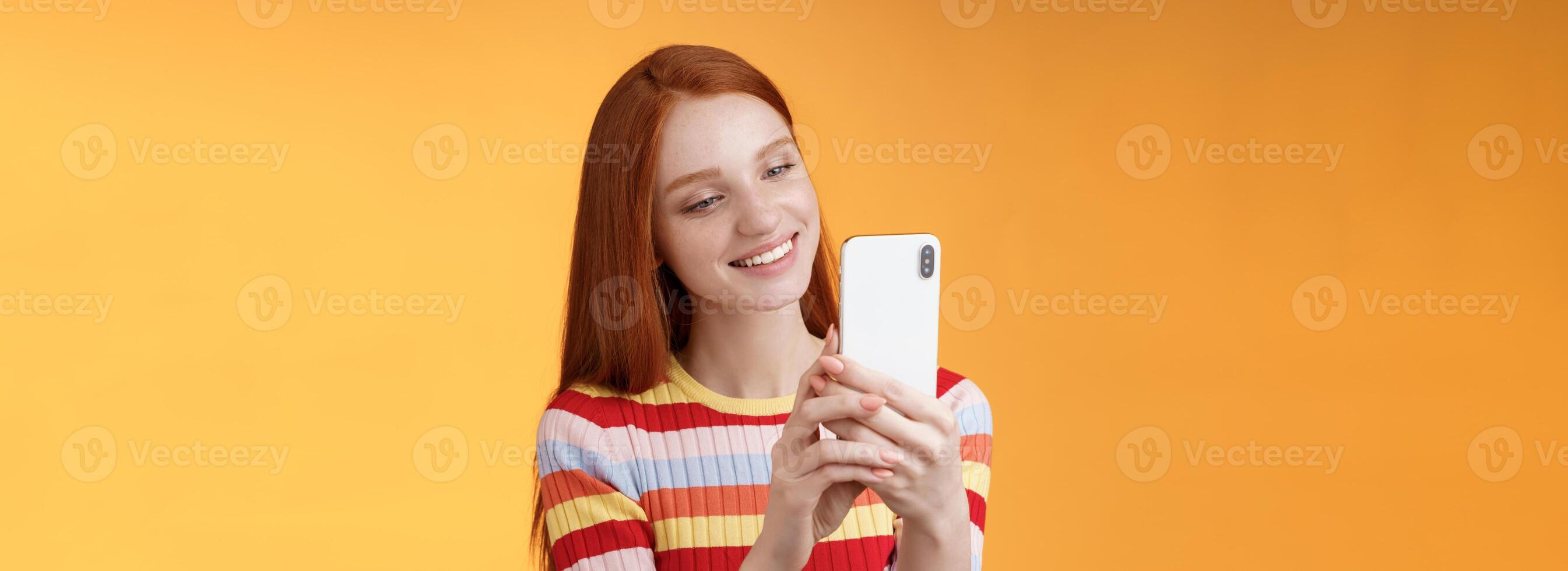 linda femenino oferta joven pelirrojo glamour niña participación teléfono inteligente tomando imágenes verano urbano vibraciones hembra blogger disparo enviar en línea historia en pie felizmente naranja antecedentes sonriente foto