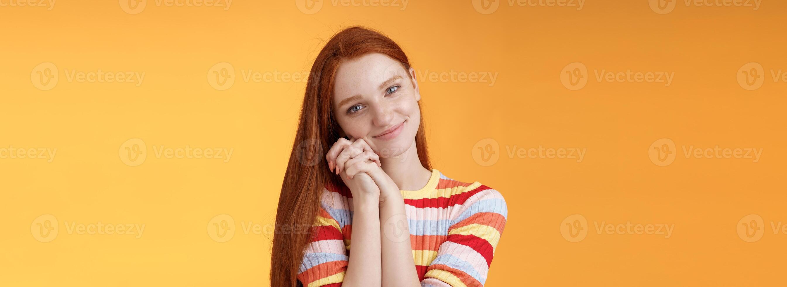 Dreamy sensual romantic young passionate redhead girlfriend melt heart feel sympathy joy receive sweet tender present lean palms smiling grateful gladly accept nice lovely gift, orange background photo