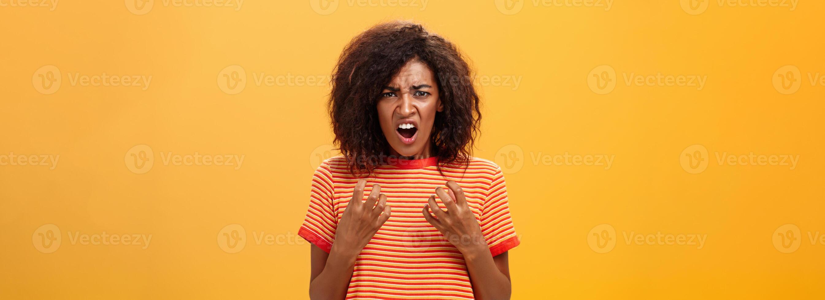 Waist-up shot of woman feeling upset feeling unfair things happened complaining and whining with regret frowning gesturing with palms near breast standing over orange background photo