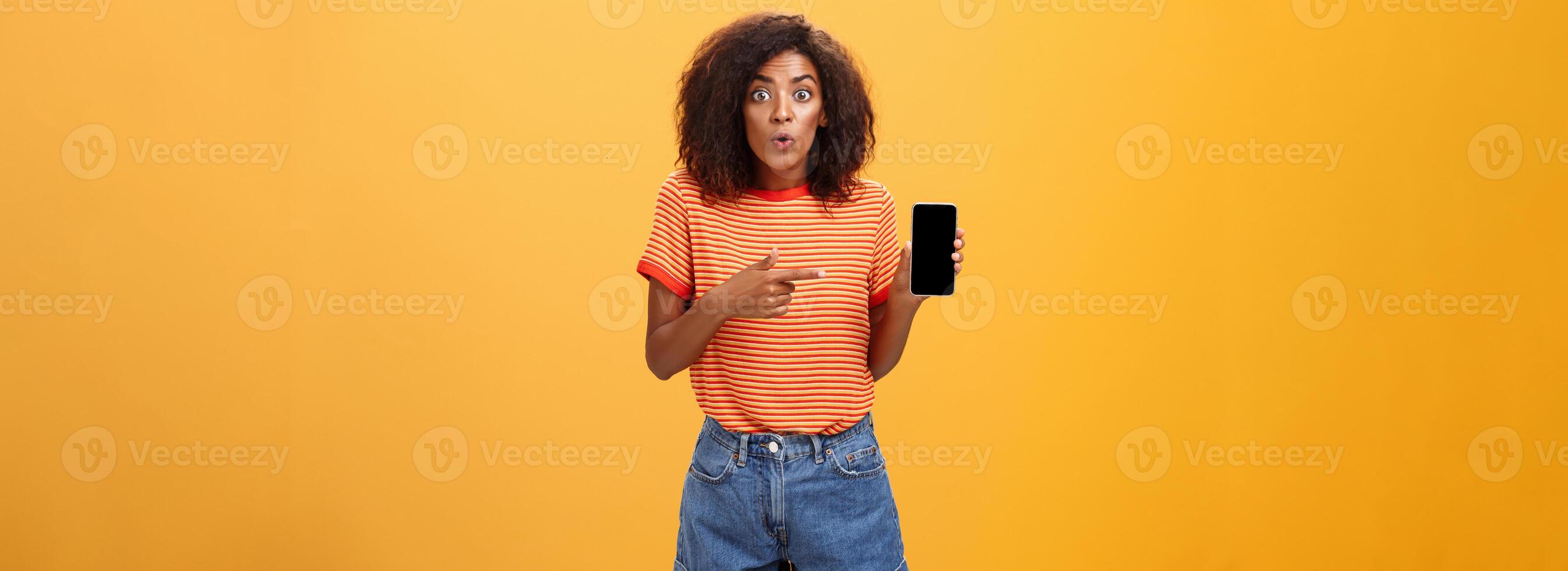 retrato de impresionado y curioso hembra amigo demostración perfil de ex a amigo hablando acerca de impactante cambios de apariencia plegable labios desde interesar participación teléfono inteligente señalando a Teléfono móvil pantalla foto