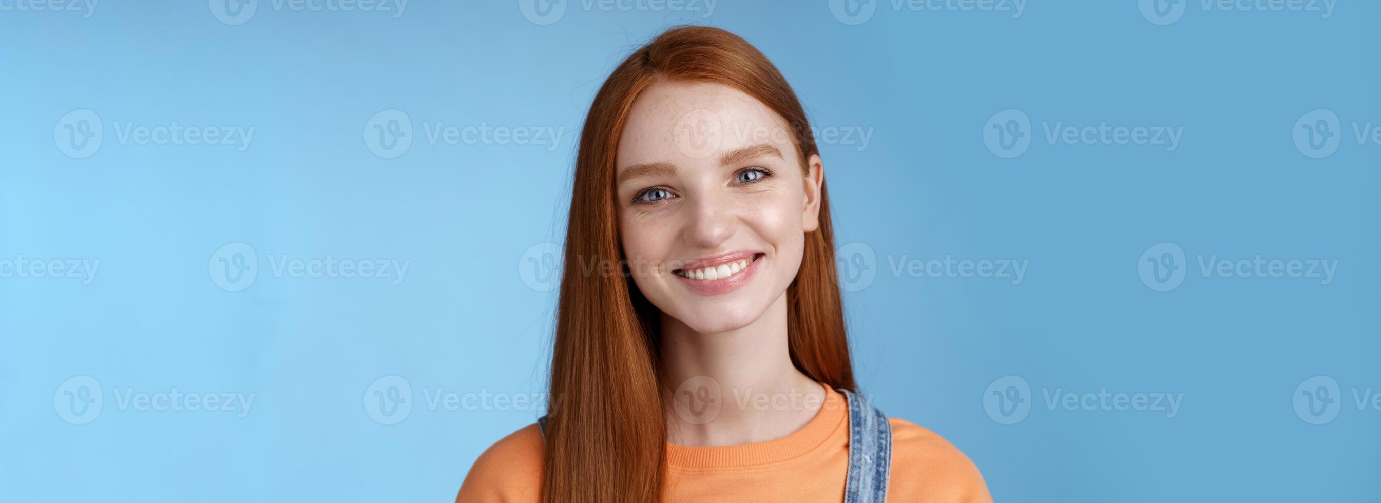 Cheerful lively redhead caucasian girl smiling happily look camera kind sincere friendly talking have perfect summer holidays talking friends standing blue background joyful photo