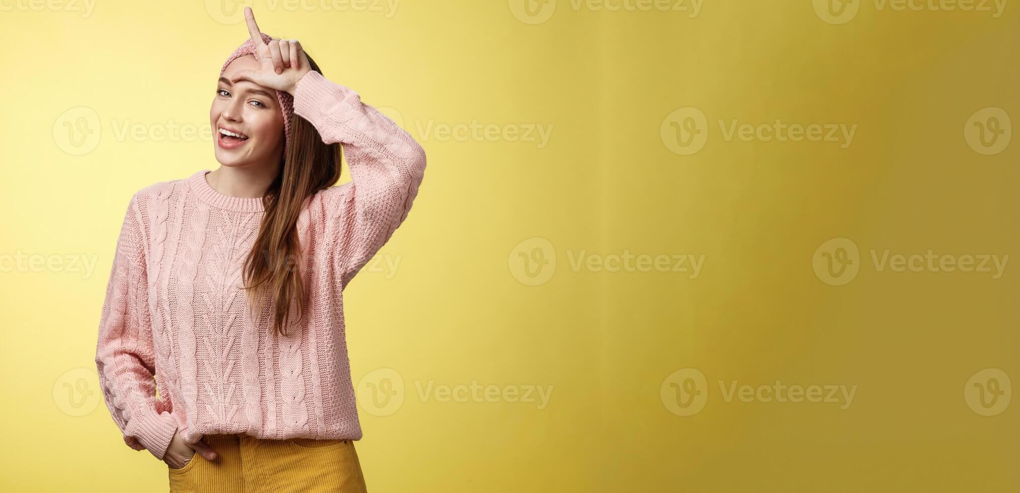 atractivo triunfando arrogante y confidente linda glamoroso mujer en de punto suéter, venda demostración l letra en frente, perdedor firmar y riendo terminado perdido equipo, burlón teniendo divertido foto