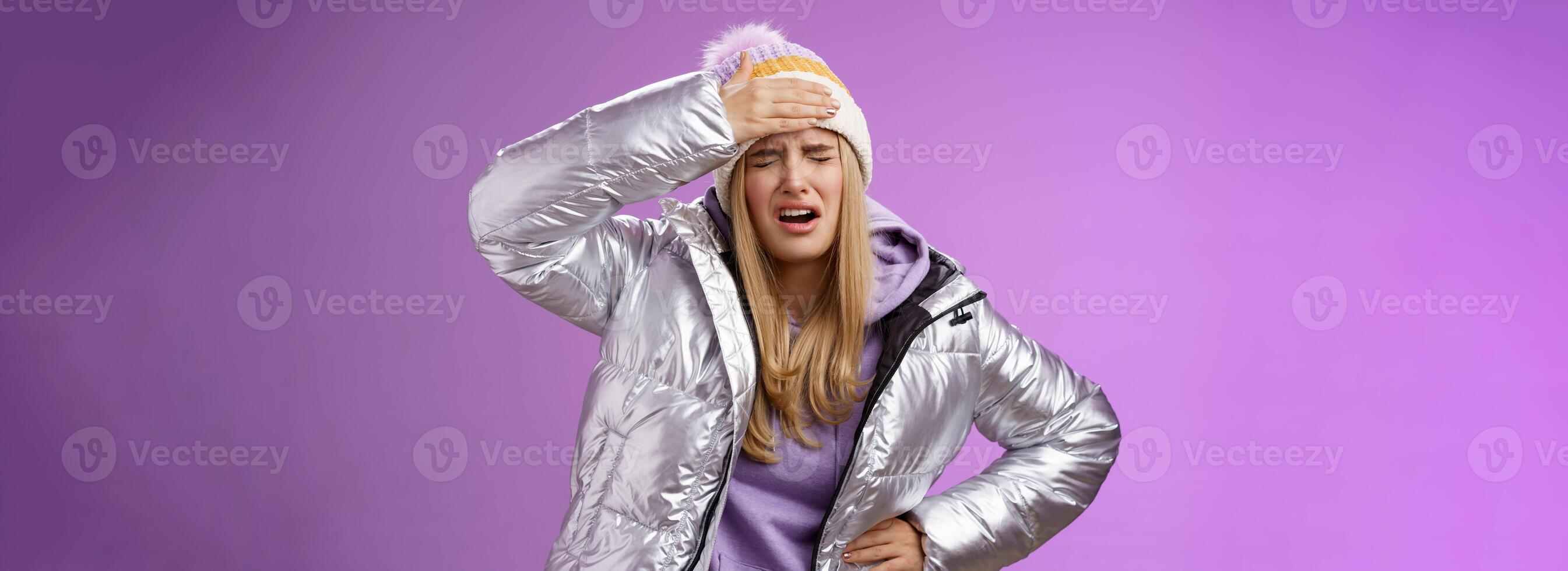 Girl sick tired touch forehead painful feeling grimacing complaining boyfriend shot snowball woman face standing bothered fed up and upset, whining displeased suffering headache, purple background photo