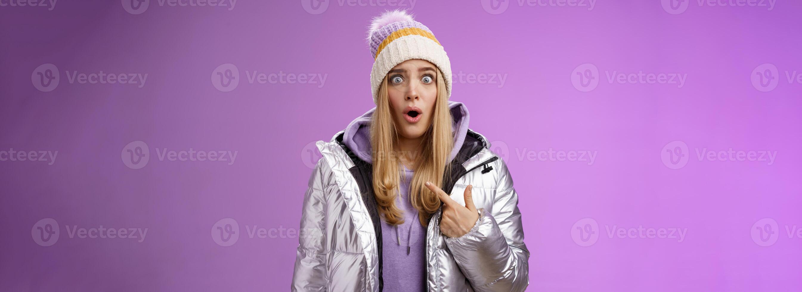 Frustrated shocked speechless stunned blond woman accused widen eyes surrpised questioned look camera pointing herself cannot believe being picked blame victim, standing purple background photo