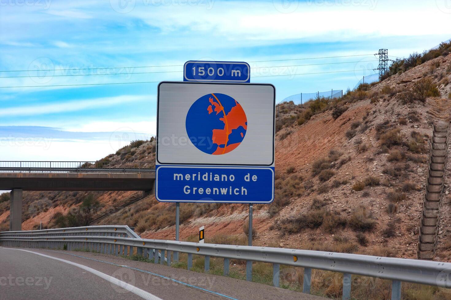 Road sign on the highway in Spain. Greenwich meridian is ahead photo