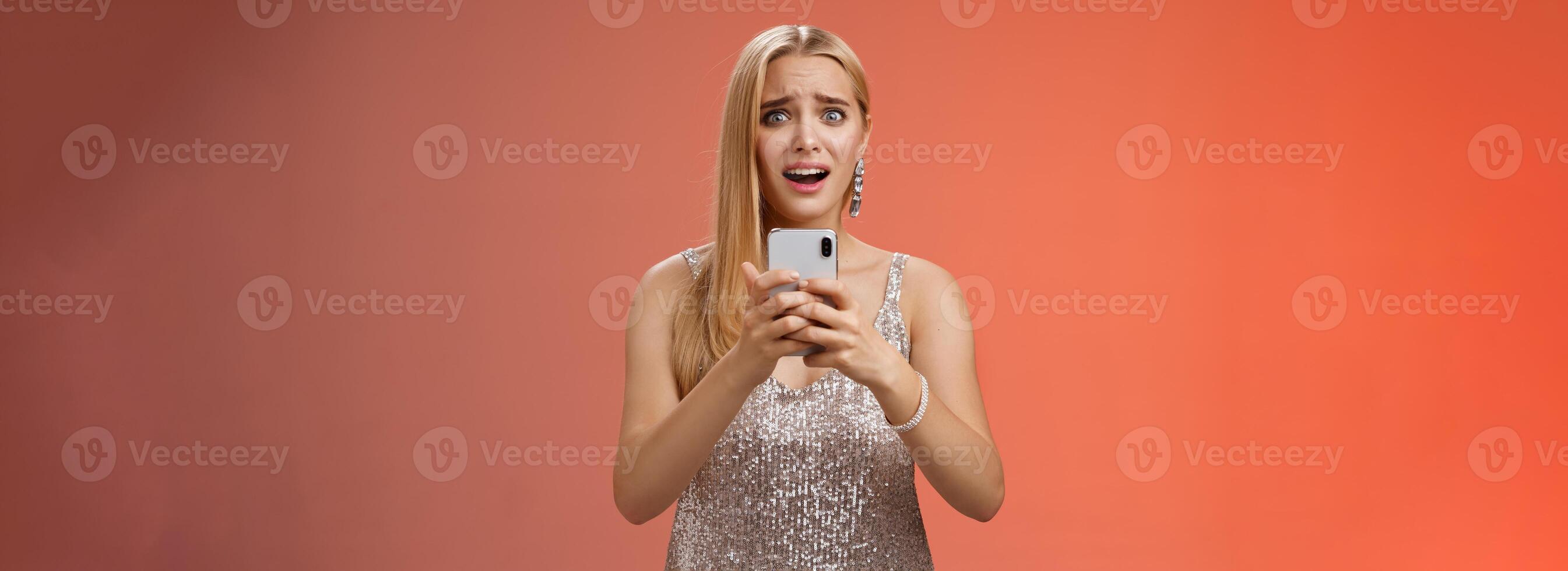 Panicking shocked woman concerned photos leaked internet look afraid anxious widen eyes cringing troubled hold smartphone shook speechless gasping terrified friends find out secret, red background