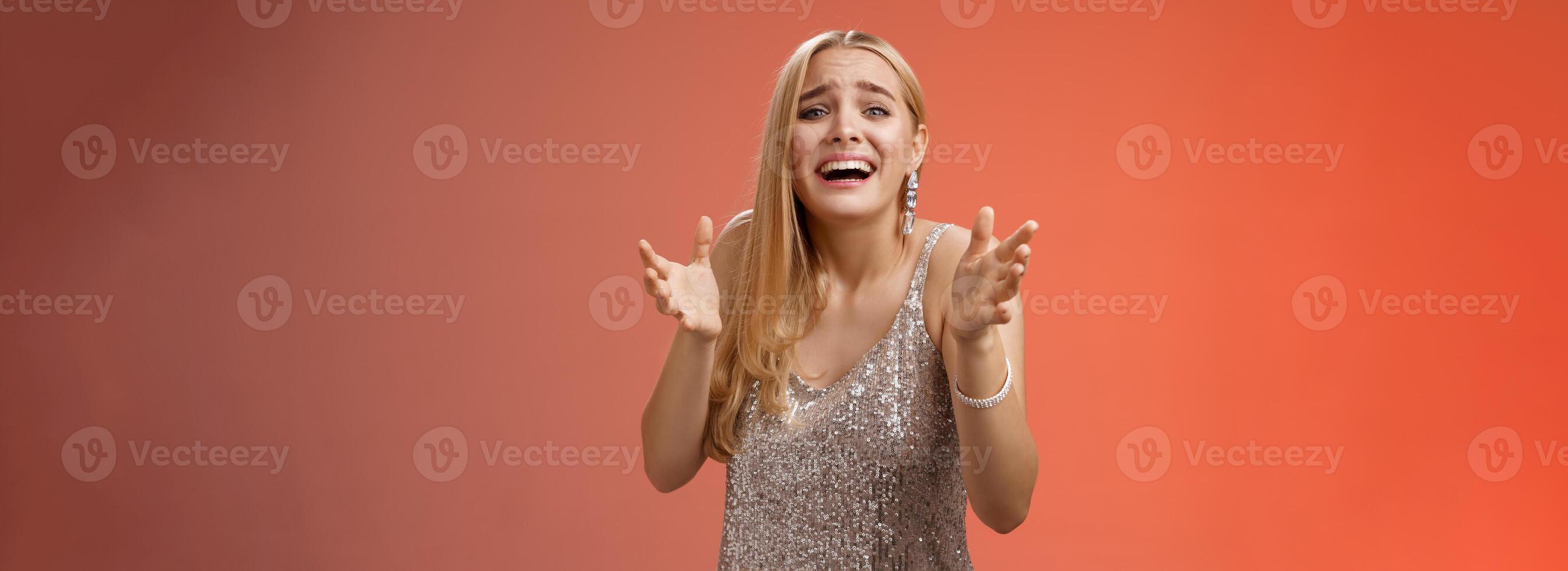 Panicking upset miserable heartbroken blond girl crying raising hands begging not go broke-up boyfriend look sorrow distressed freak-out standing devastated red background during party photo