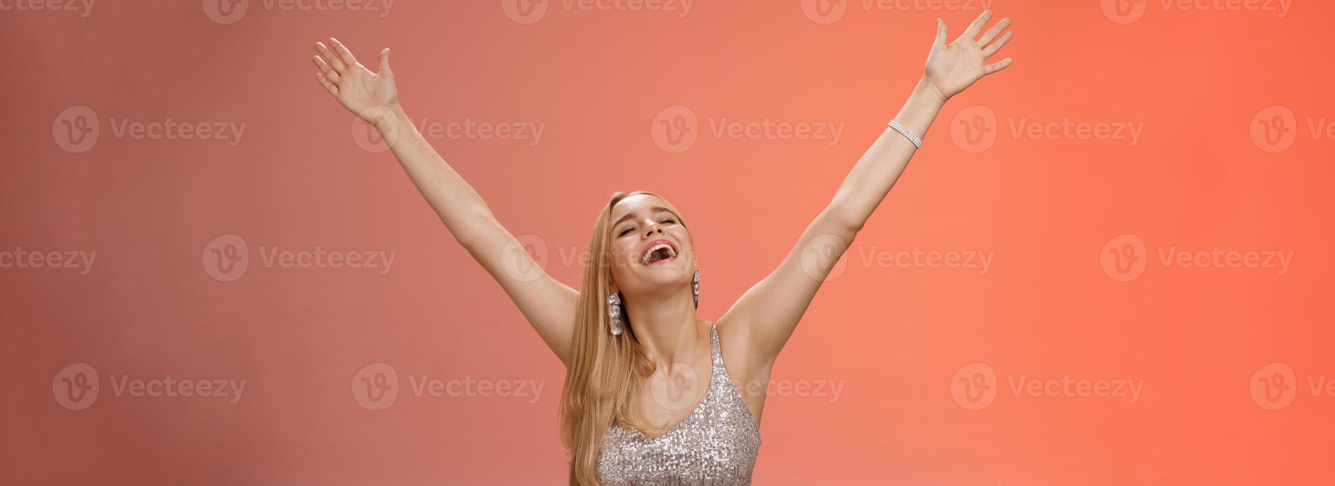 Waist-up carefree happy girl fulfill dream raising hands up sky joyfully close eyes smiling celebrating good perfect news triumphing achieve success victory, standing thrilled red background photo