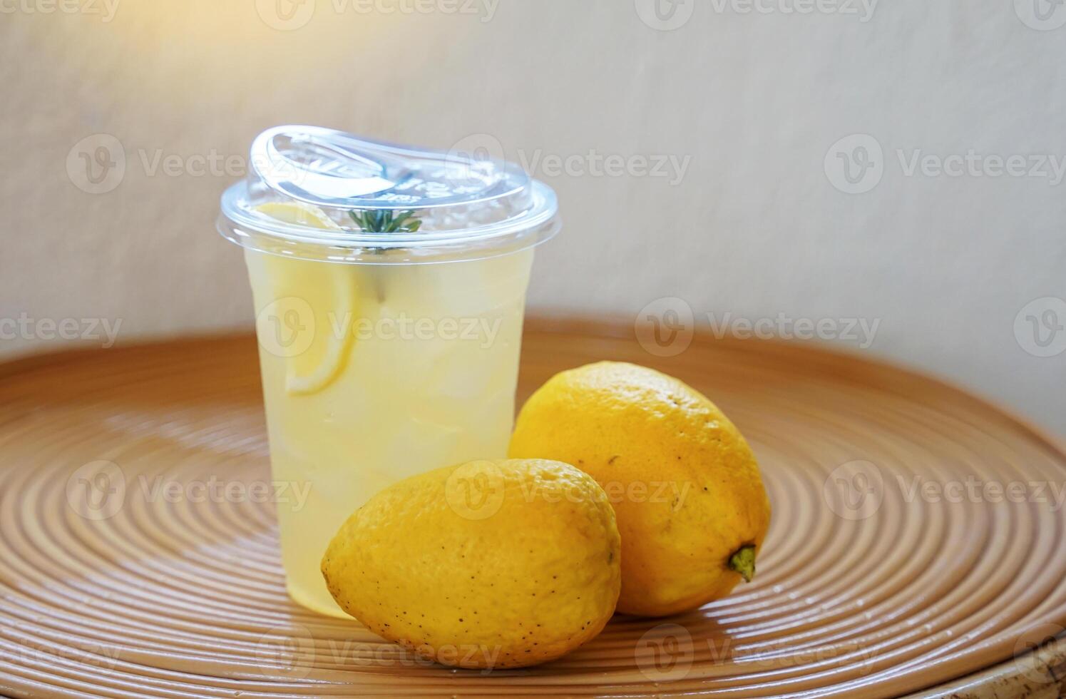 A glass of lemon soda drink is placed together with a lemon on a rattan table. It is a menu made from lemon juice that is rich in vitamin C. It is beneficial to health and helps to refresh. photo