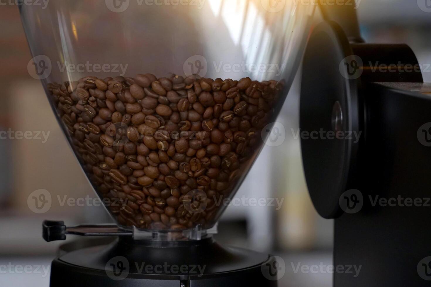 Roasted coffee beans in a coffee grinder jar Use it to brew fresh coffee or espresso shots. The drinker will experience the taste of the coffee beans and the aroma more than instant coffee. photo