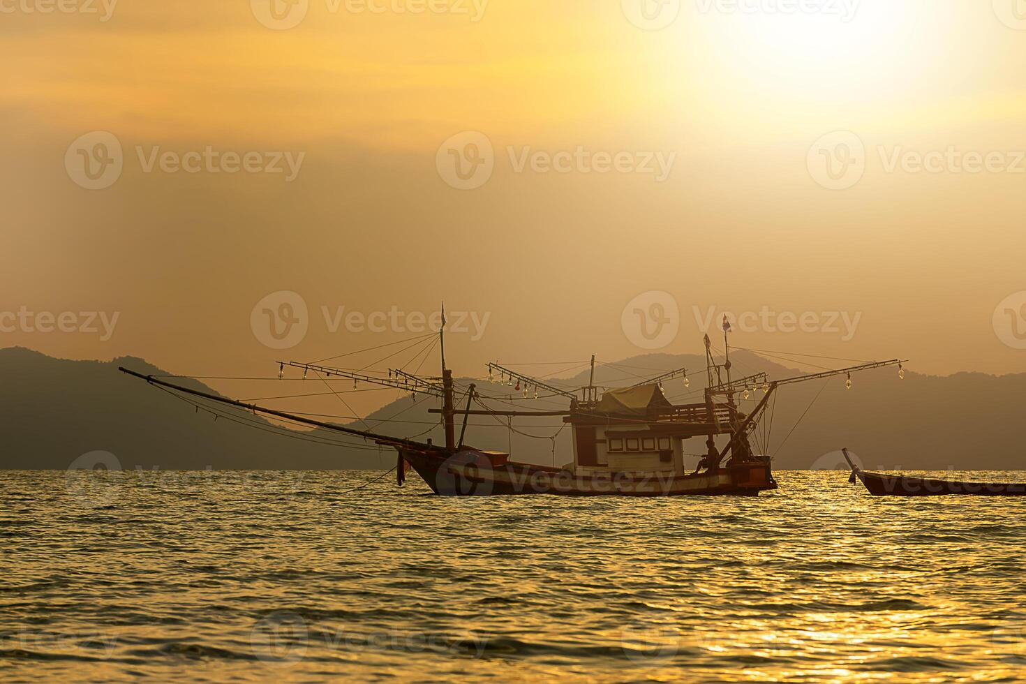 Silhouettes of Fishing boat on the sea photo