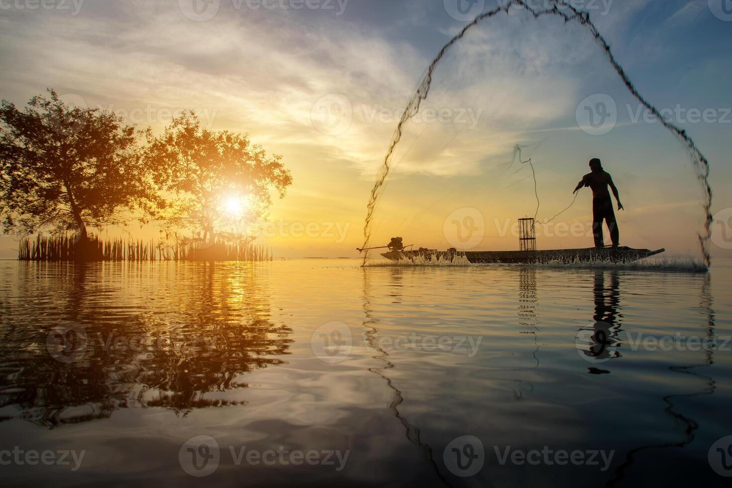 Silhouettes fisherman throwing fishing nets photo