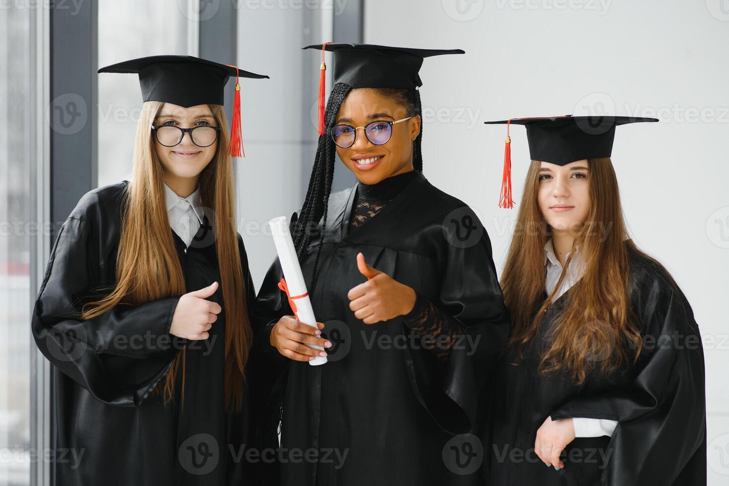 portrait of multiracial graduates holding diploma photo