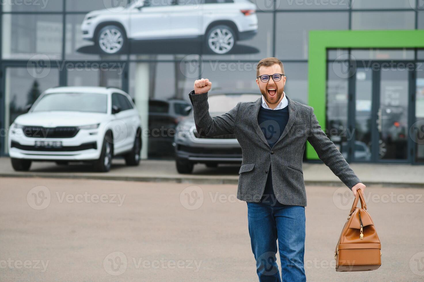 Young man in the car dealership. photo