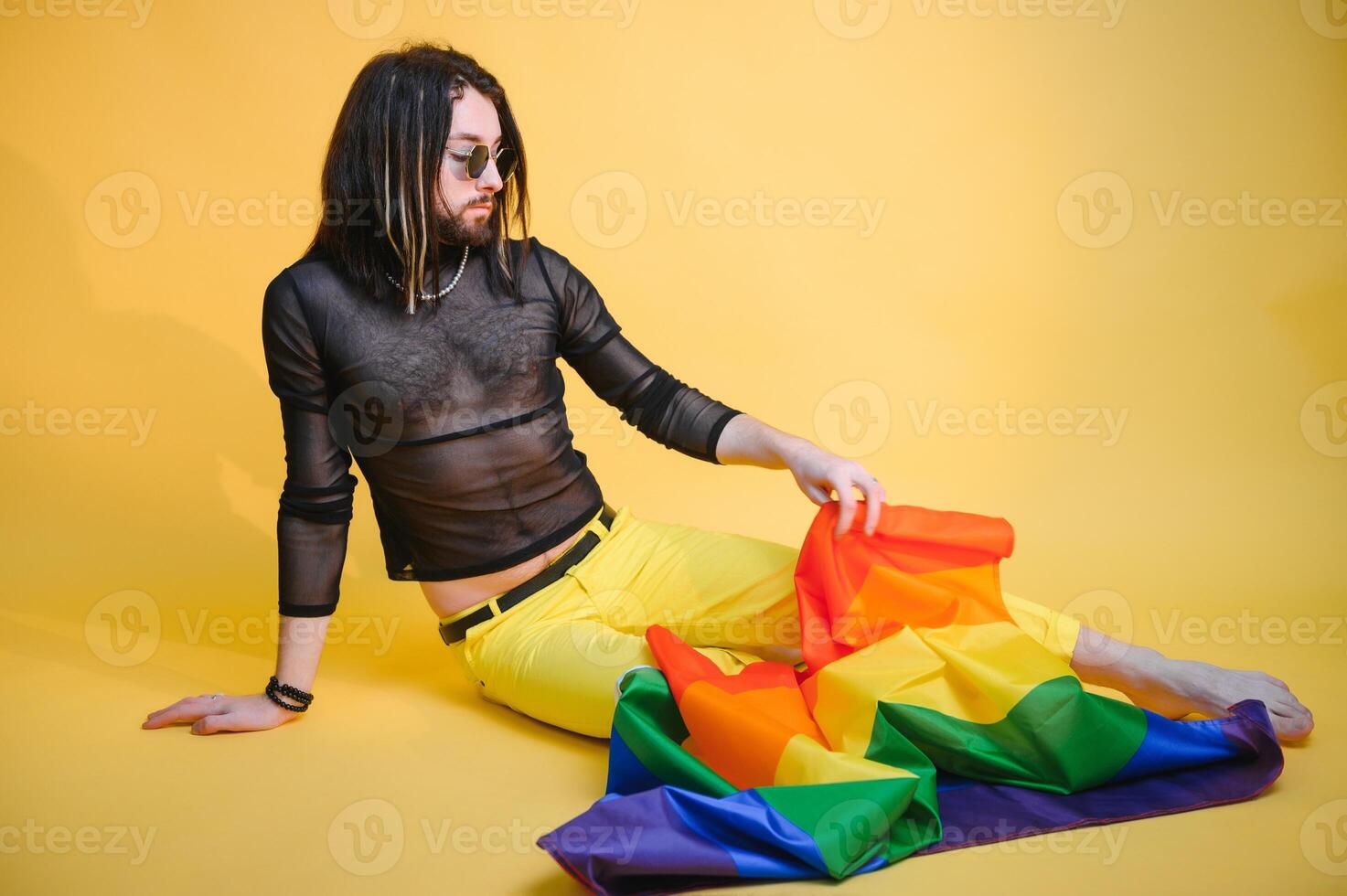 Portrait of a young guy looking happy on collored background. Gender fluid young man laughing on collored background. photo