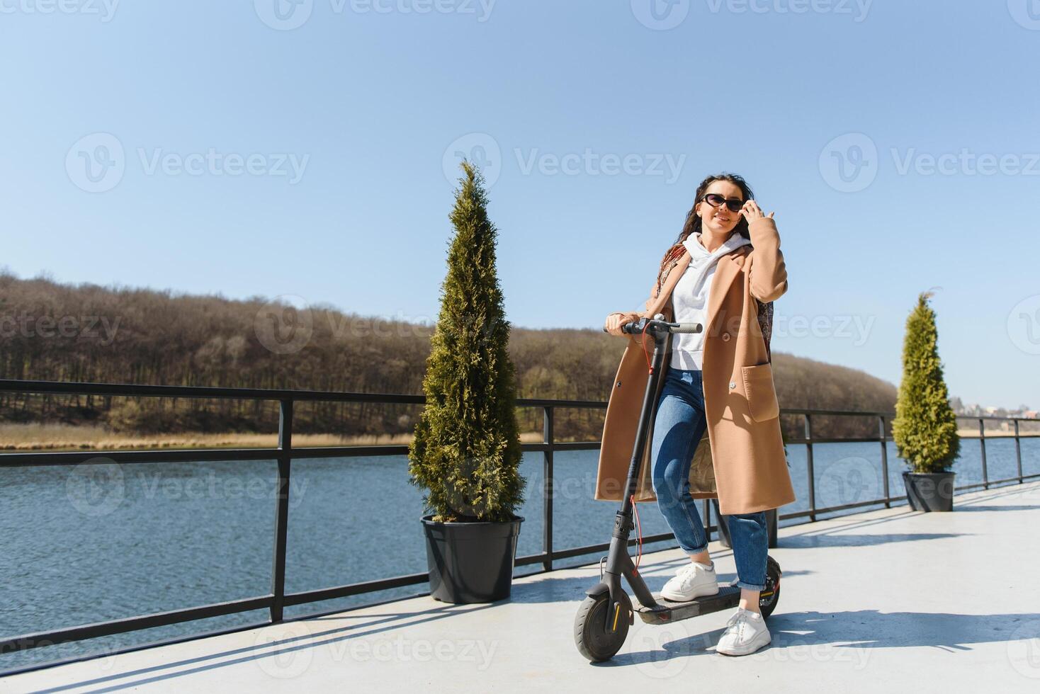 joven mujer con eléctrico scooter a el ciudad foto