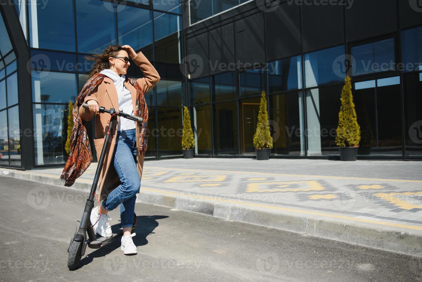 Young beautiful woman riding an electric scooter to work, modern girl, new generation, electric transport, ecology, ecological transport, sunset photo