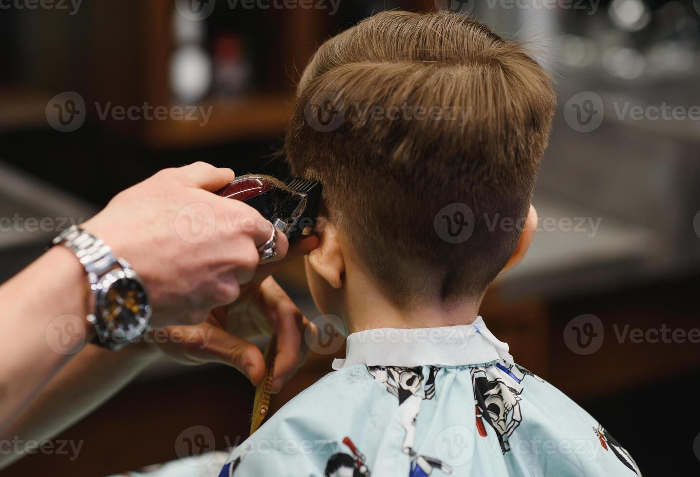 Cheerful Caucasian boy getting hairstyle in barbershop photo