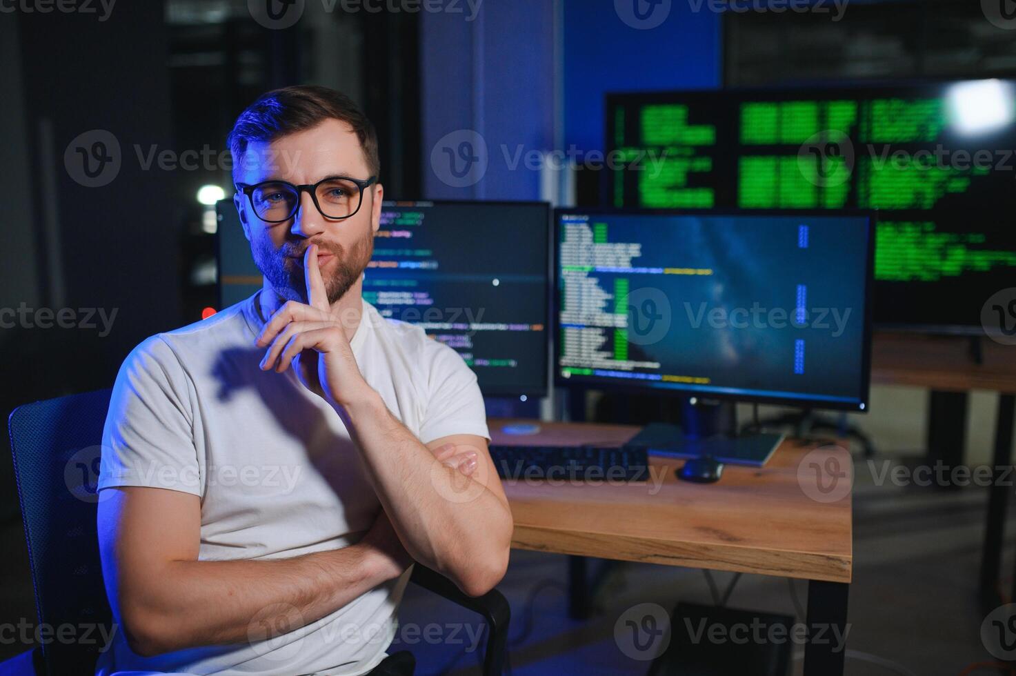 Male programmer working on desktop computer at white desk in office photo