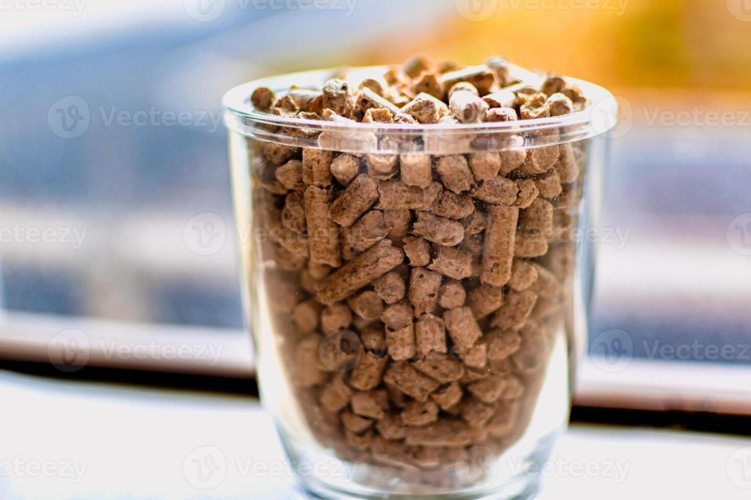 Pellet for stove or boiler in a glass, compressed wood granule photo