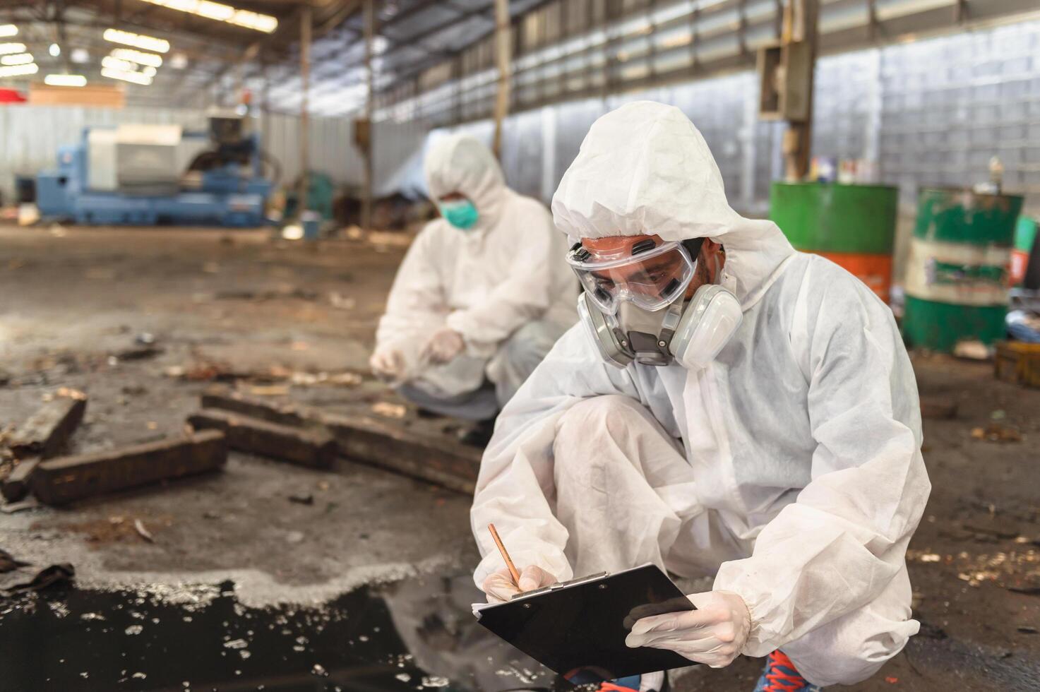 chemical specialist wear safety uniform and gas mask inspecting chemical leak in industry factory photo